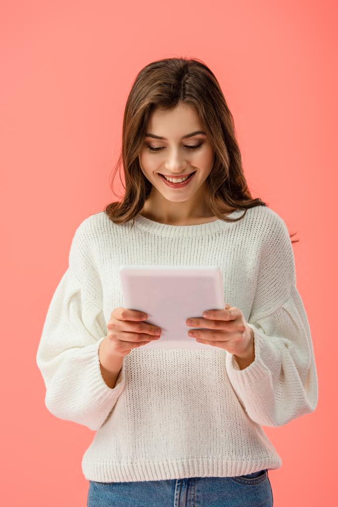 усміхнена і красива молода жінка тримає цифровий планшет ізольовано на рожевому
   - Фото, зображення