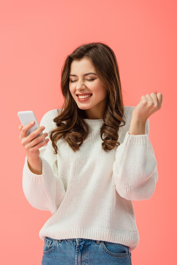 glückliche und attraktive Frau in weißem Pullover, Smartphone isoliert auf rosa - Foto, Bild
