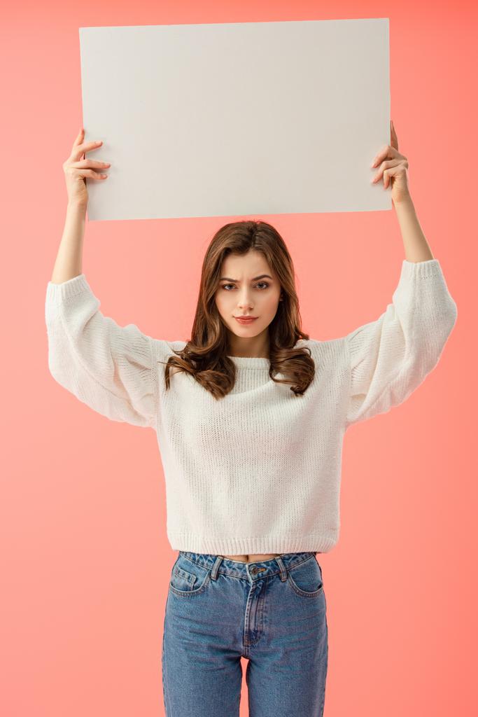 sad woman in white sweater holding empty board with copy space isolated on pink - Photo, Image