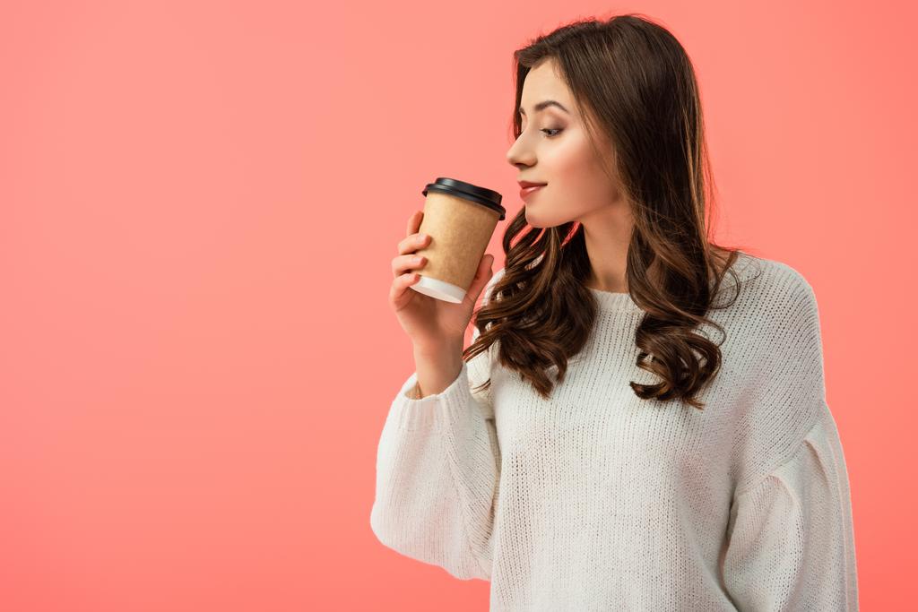 beautiful young woman in white sweater holding paper cup isolated on pink - Photo, Image