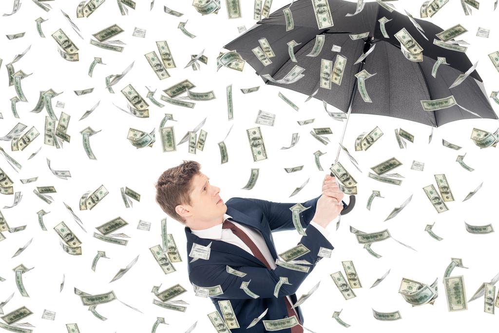 succesvolle zakenman in pak paraplu houden geld de regen - Foto, afbeelding