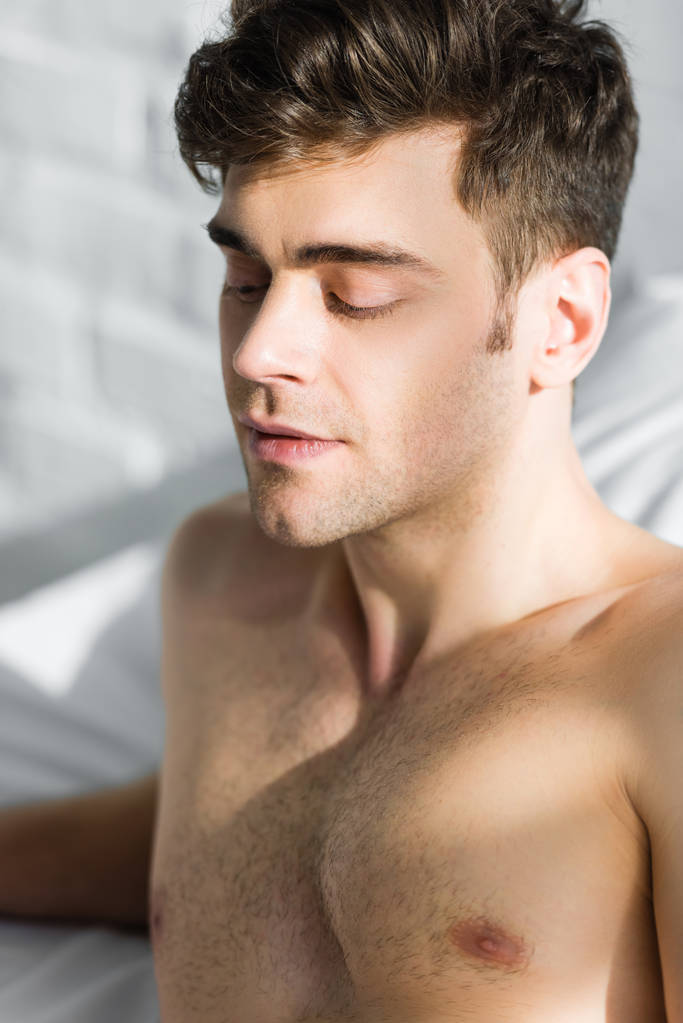 портрет красивого мужчины с голым туловищем на кровати
 - Фото, изображение