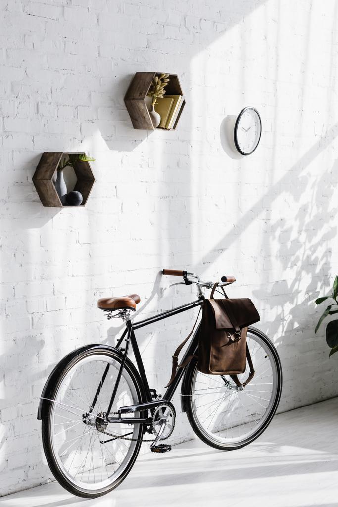 オフィスの壁の白レンガの近くにバッグと黒の自転車 - 写真・画像