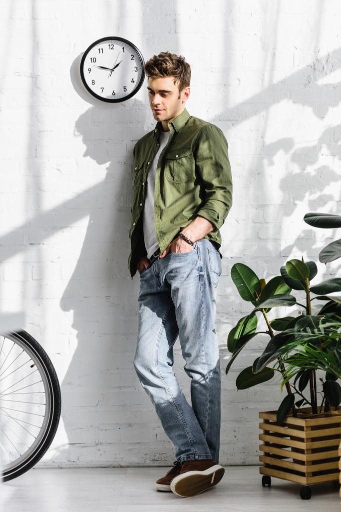 Aumentar Macadán híbrido Foto e imagen de stock sin royalties de Hombre Guapo En Camisa Verde Y Jeans