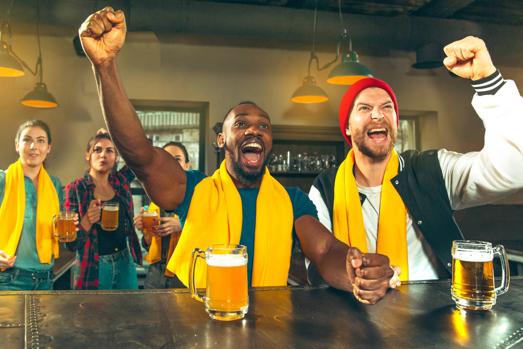 Спорт, люди, дозвілля, дружба та розваги - щасливі шанувальники футболу чи друзі-чоловіки п'ють пиво та святкують перемогу в барі чи пабі
 - Фото, зображення