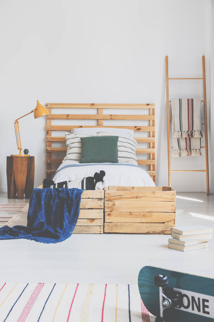 Foto reale di un interno camera da letto con un letto e pallet come poggiatesta
 - Foto, immagini