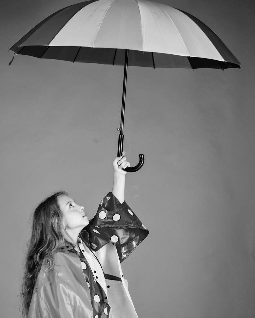 Αδιάβροχο αξεσουάρ για παιδιά. Ευτυχισμένο παιδί κορίτσι κρατήστε φθορά ομπρέλα αδιάβροχο μανδύα. Απολαύστε βροχερός καιρός με κατάλληλα ενδύματα. Αδιάβροχο αξεσουάρ κάνουν βροχερή μέρα χαρούμενη και ευχάριστη - Φωτογραφία, εικόνα