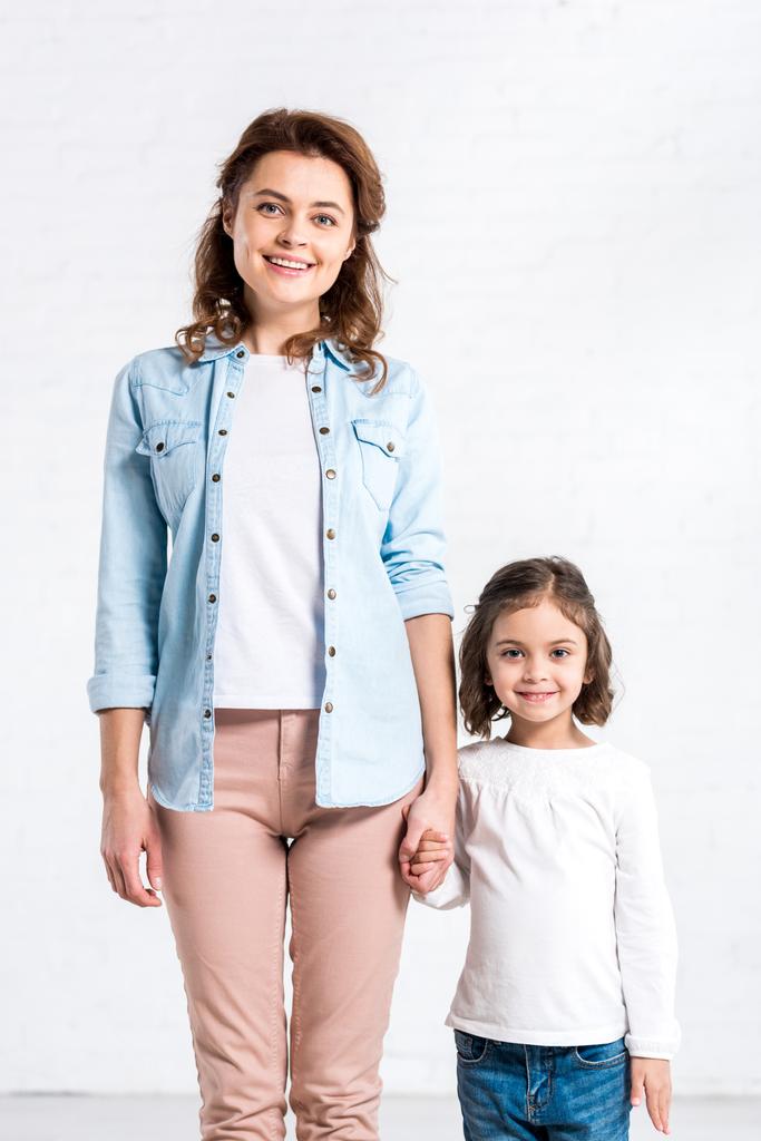 Smiling mother and daughter holding hands on white  - Photo, Image
