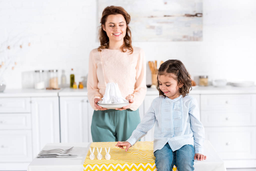 Sonriendo feliz madre e hija sirviendo mesa en la cocina
 - Foto, Imagen