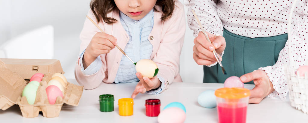 Panoramic shot of mother and daughter painting easter eggs  - Photo, Image