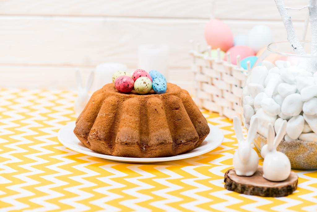 Easter bread with colorful painted eggs and ceramic rabbits on table - Photo, Image