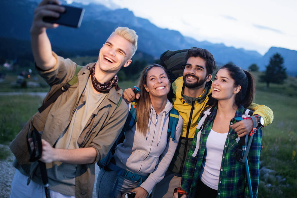 Ryhmä ystäviä lepää vuorella, kun vaellus
 - Valokuva, kuva