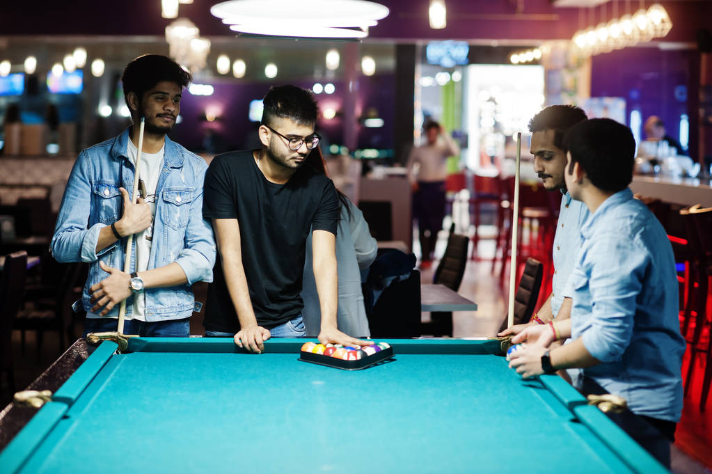 Groep van stijlvolle Aziatische vrienden slijtage op jeans spelen pool Carlton - Foto, afbeelding