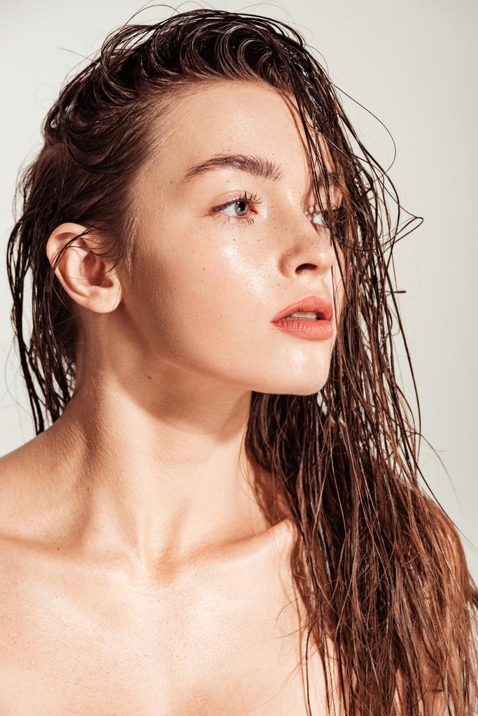 schöne junge Frau mit korallenen Lippen und nassen Haaren, die isoliert von grau wegschaut - Foto, Bild
