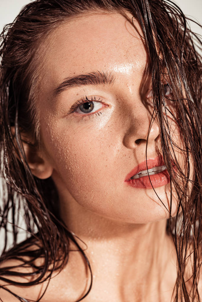 サンゴの唇と濡れた髪がカメラ目線で美しい魅惑的な若い女性 - 写真・画像