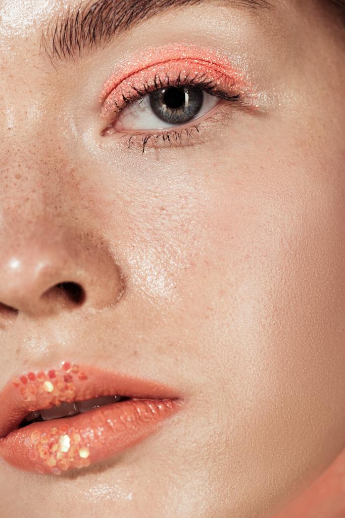 Close up van vrouw met koraal glitter make-up camera kijken - Foto, afbeelding