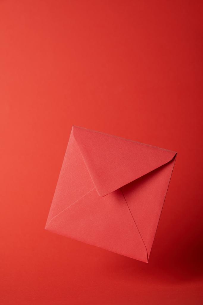 envelope brilhante, colorido e vazio no fundo vermelho com espaço de cópia
  - Foto, Imagem