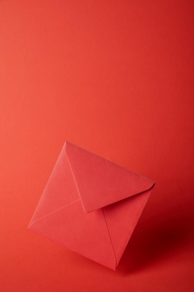 envelope brilhante, colorido e vazio no fundo vermelho com espaço de cópia
  - Foto, Imagem