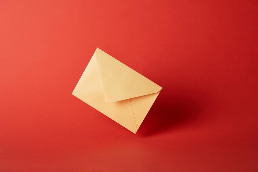 enveloppe lumineuse, colorée et jaune sur fond rouge avec espace de copie
  - Photo, image