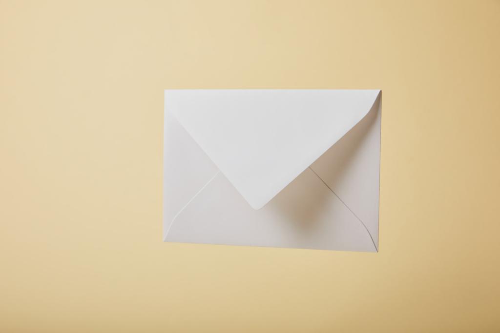 white and empty envelope on yellow background with copy space  - Photo, Image