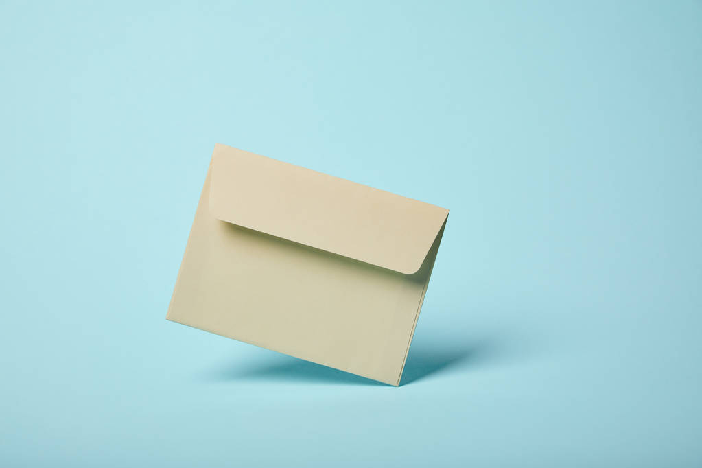 enveloppe beige et vierge sur fond bleu avec espace de copie
  - Photo, image
