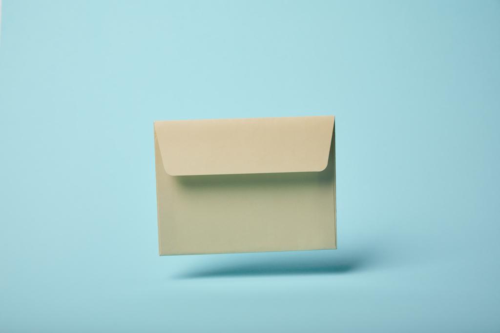 beige and empty envelope on blue background with copy space  - Photo, Image