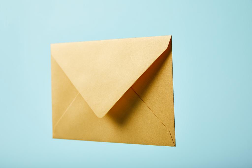 envelope amarelo e brilhante isolado em azul com espaço de cópia
 - Foto, Imagem