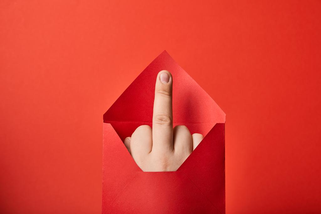 частковий вид людини, що показує середній палець у яскравому конверті на червоному тлі
 - Фото, зображення