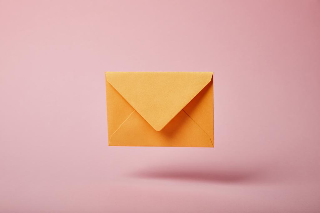 yellow and colorful envelope on pink background with copy space - Photo, Image