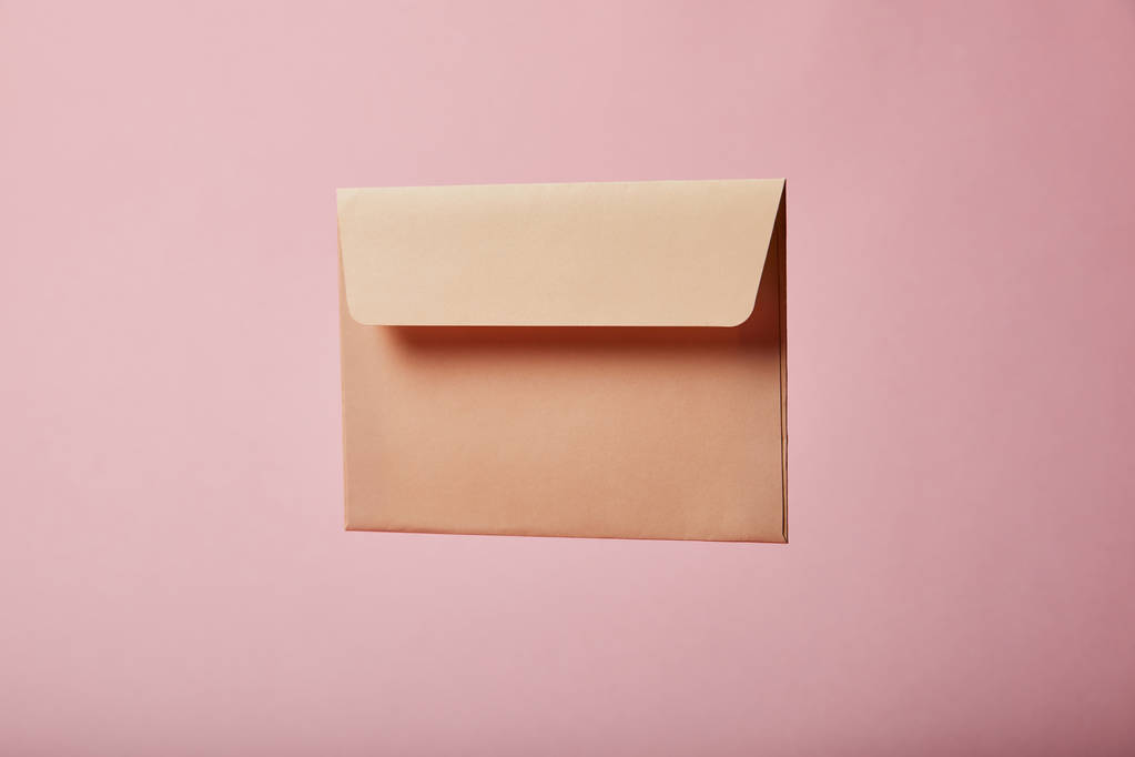 beige en lege envelop op roze achtergrond met kopie ruimte - Foto, afbeelding