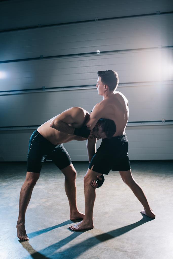 мускулистый боец Мма делает удушающий захват в клинче спортивному противнику без рубашки
  - Фото, изображение