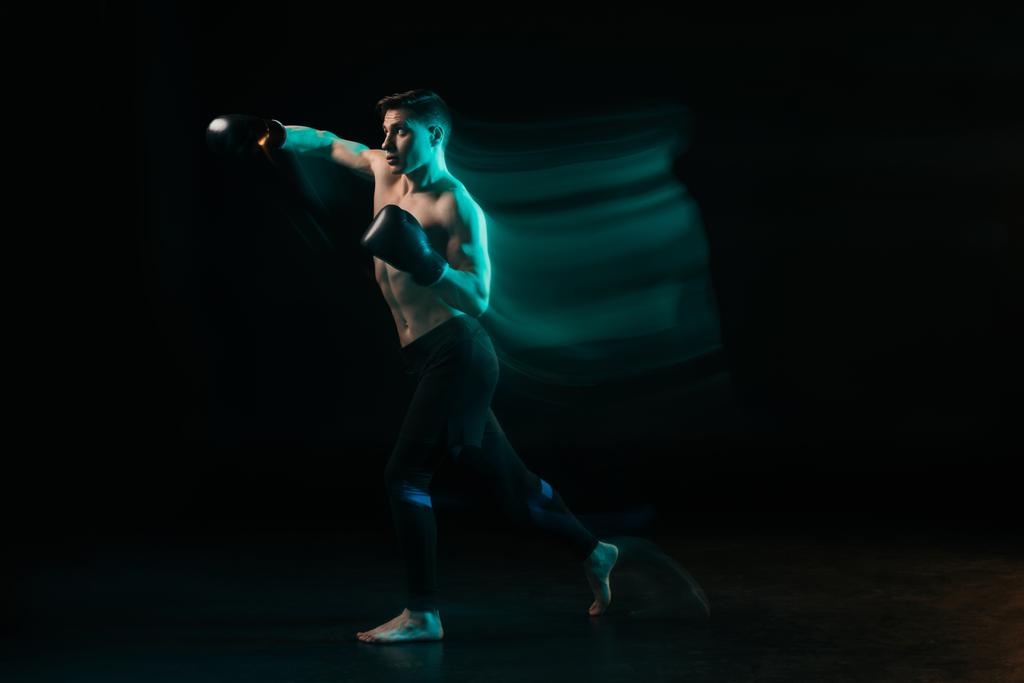 yeşil ışık ve sportif kas mma savaşçı yumruk siyah yapıyor uzun pozlama - Fotoğraf, Görsel