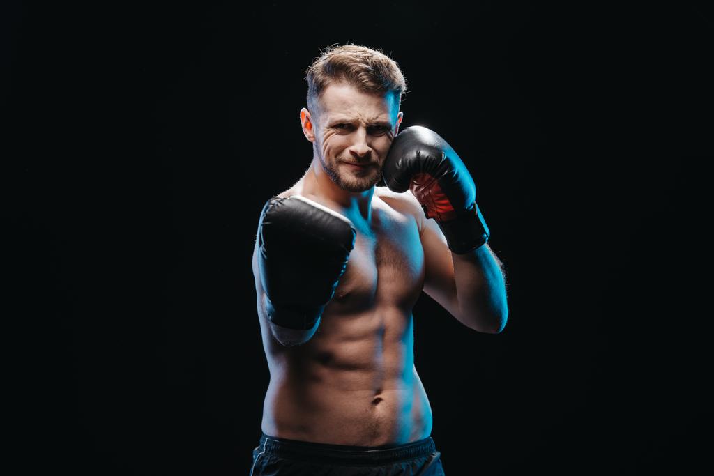 svalová shirtless namáhavé boxer v Boxerské rukavice vede úder na fotoaparát izolované na černém pozadí - Fotografie, Obrázek