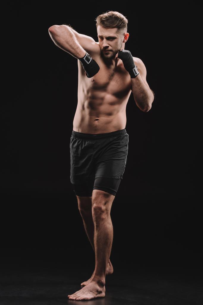 μυϊκή ΜΜΑ μαχητής με γάζες κάνει γροθιά με τον αγκώνα σε μαύρο - Φωτογραφία, εικόνα