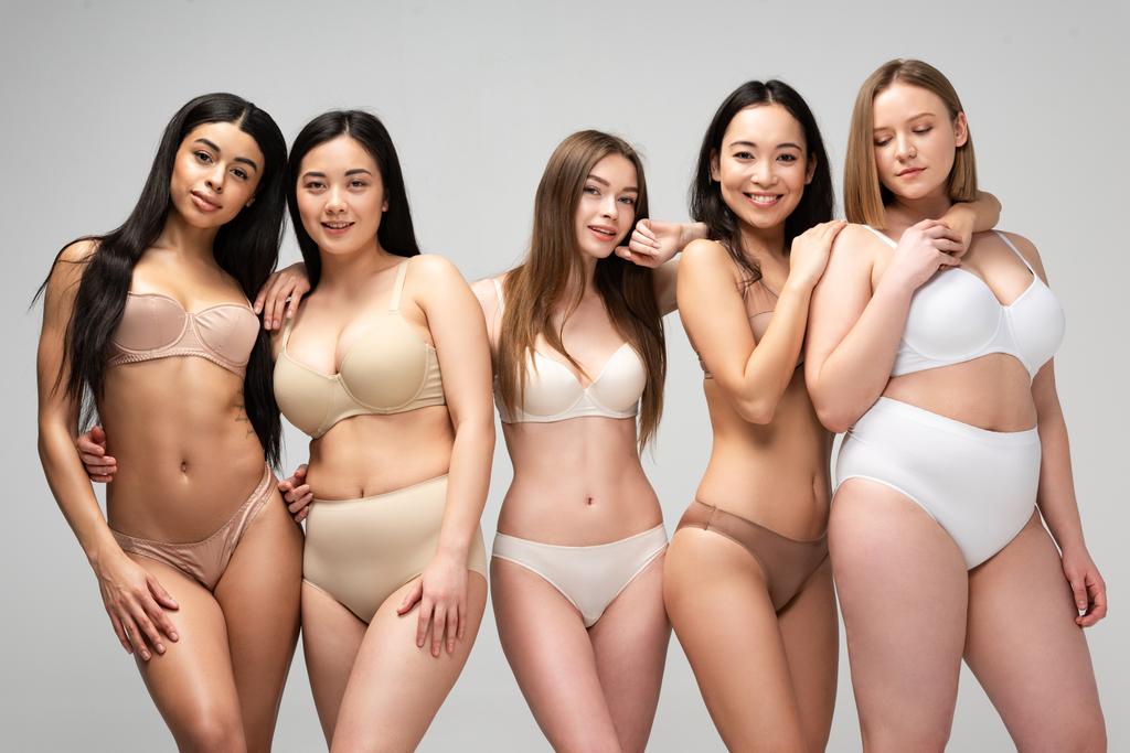 fünf attraktive junge multiethnische Frauen in Unterwäsche posieren isoliert auf grauem, körperpositivem Konzept vor der Kamera - Foto, Bild