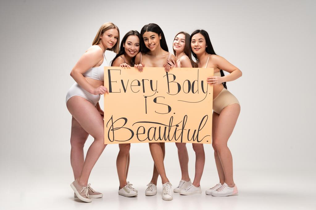 beş genç ve güzel çok ırklı kadın iç çamaşırı ve afiş "her beden güzeldir" yazıt ile tutan spor ayakkabı  - Fotoğraf, Görsel