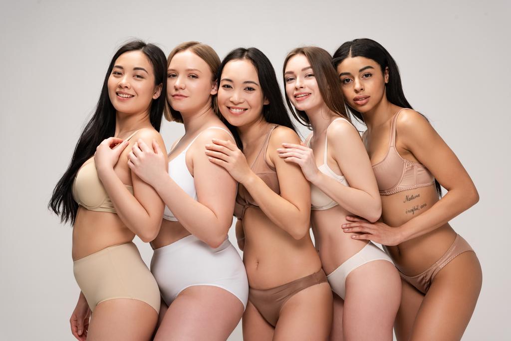 cinq jeunes femmes heureuses s'embrassant et souriant isolé sur gris, concept de positivité du corps
 - Photo, image