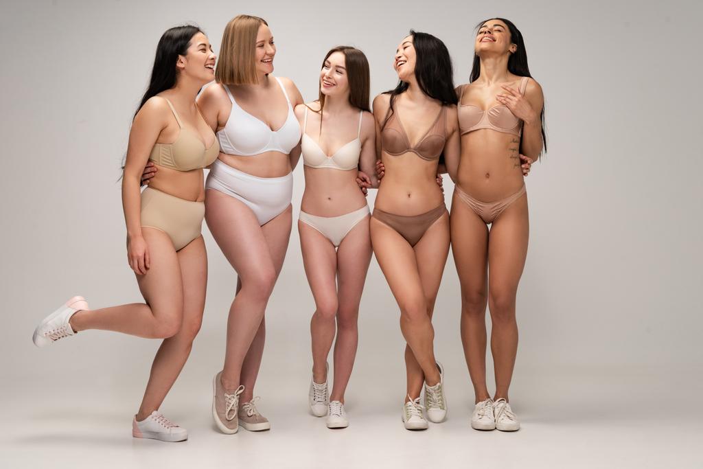 cinq jeunes femmes multiculturelles gaies en lingerie étreignant tout en posant à la caméra, concept de positivité du corps
 - Photo, image