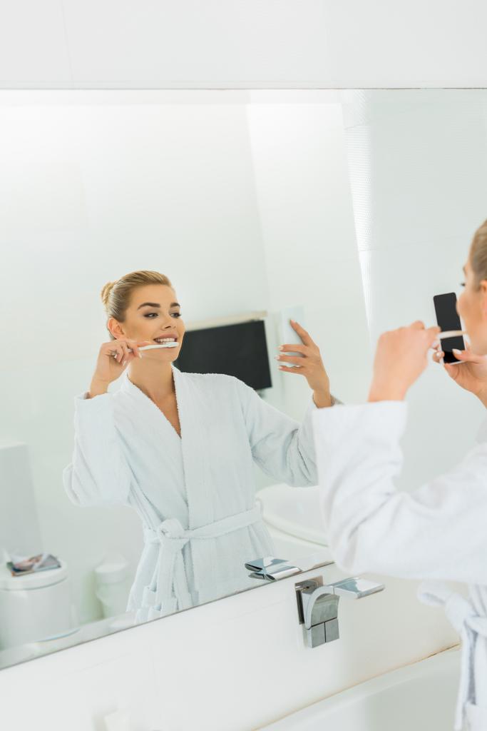 вибірковий фокус жінки в білому халаті чистити зуби і приймати селфі
 - Фото, зображення