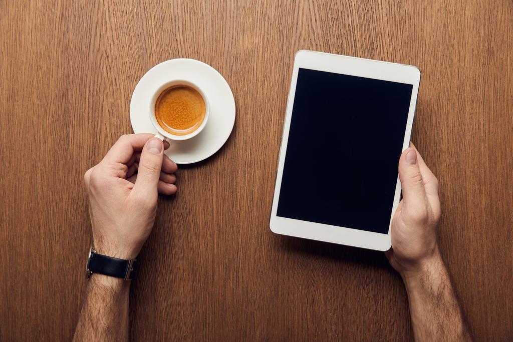 oříznutý pohled člověka drží digitální tablet s prázdnou obrazovkou a šálek kávy - Fotografie, Obrázek