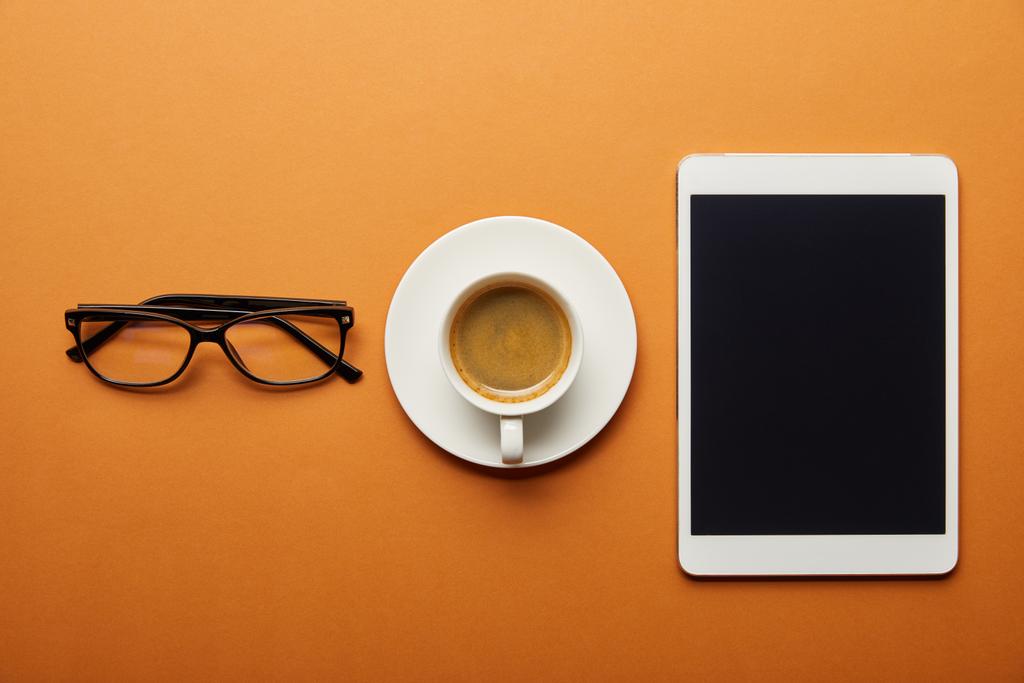 top view of digital tablet with blank screen near cup with drink and glasses on orange  - Photo, Image