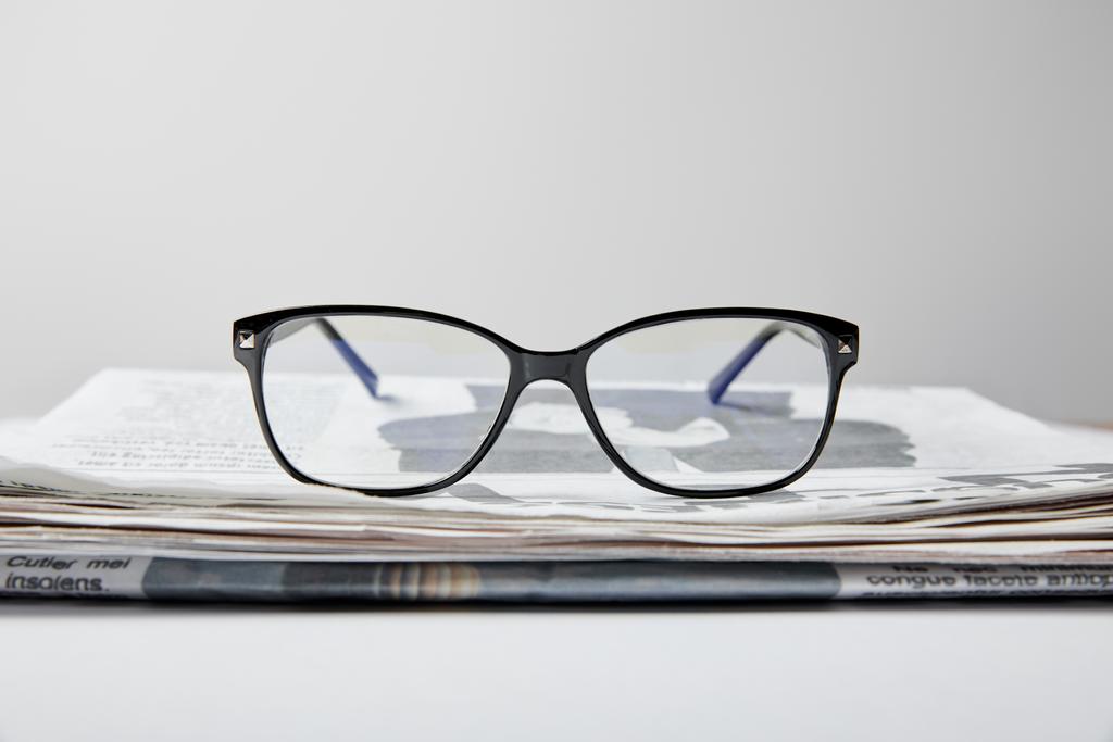 επιλεκτική εστίαση των γυαλιών κοντά σε εφημερίδα σε λευκό  - Φωτογραφία, εικόνα