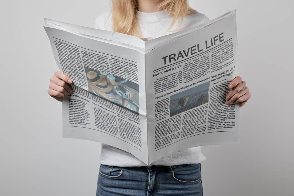 przycięte widzenia kobietę podróży gazety na szarym tle  - Zdjęcie, obraz