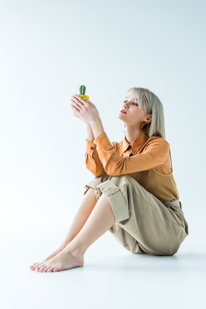 krásná stylová holka drží kaktus rostlin na bílém  - Fotografie, Obrázek
