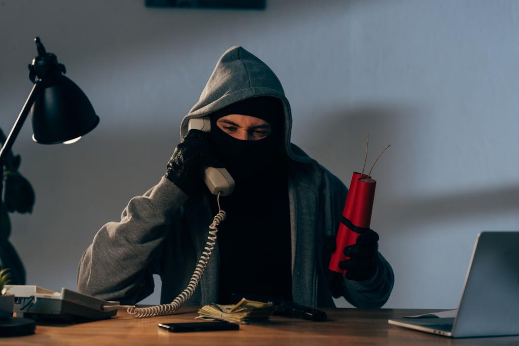Terrorista maszk gazdaság dinamit és beszél telefonon - Fotó, kép