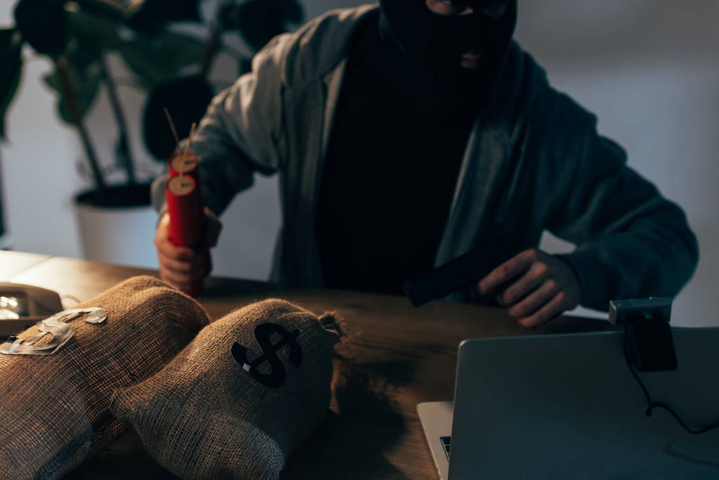 Kasvanut näkymä terroristi ase ja dynamiitti istuu pöydässä rahaa pussit
 - Valokuva, kuva