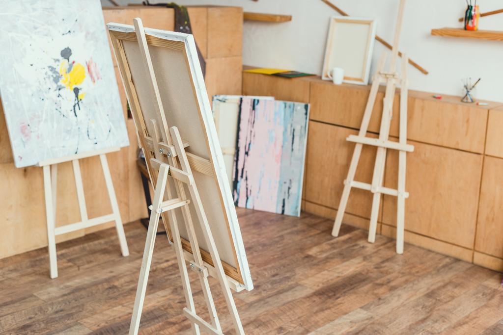 painting studio with wooden floor, cabinets, easels and paintings  - Photo, Image