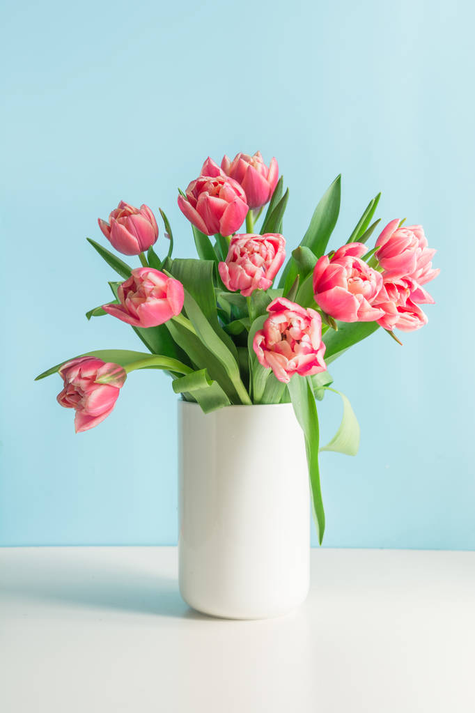 Strauß roter Tulpe in Vase auf blauem Grund. Muttertag. - Foto, Bild