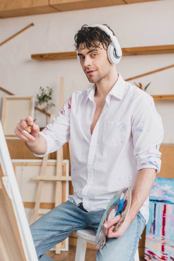 enfoque selectivo de artista guapo escuchando música con auriculares
  - Foto, Imagen