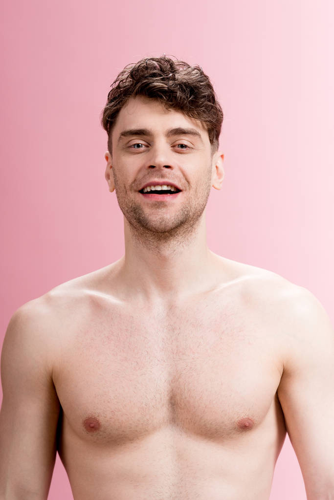 hezký, usměvavá brunetka muž při pohledu na fotoaparát na růžová - Fotografie, Obrázek